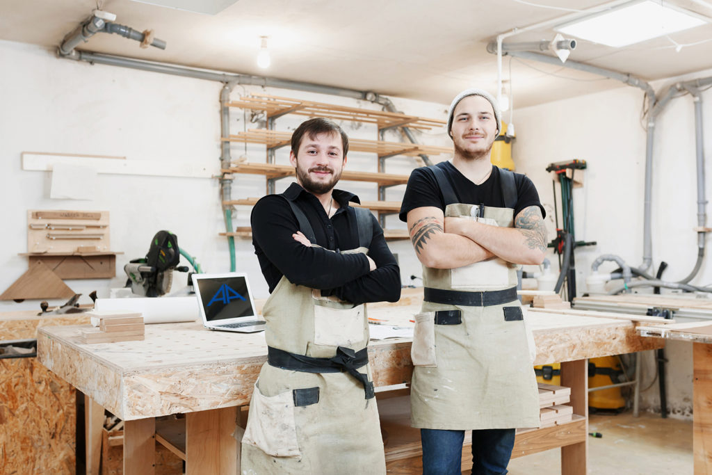 zwei junge tischler stehen in der Werkstatt